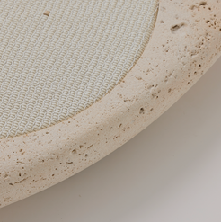 Close-up of a textured beige circular wireless phone charger  with a white woven leather centre